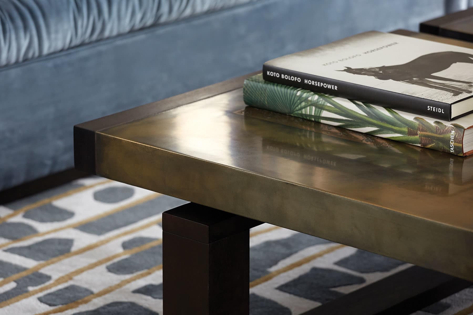 Bespoke brass coffee table on a luxurious patterned rug.